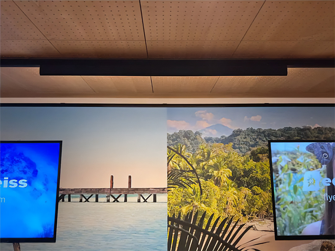 A linear wall wash track light illuminates an art and digital advertising wall in a train station in Munich, Germany.